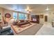 Inviting living room with a comfortable sectional, large windows, and a decorative wall unit at 7908 Horse Bridle St, Las Vegas, NV 89131