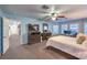 Bright main bedroom featuring an office space, ceiling fan and bright blue walls at 7908 Horse Bridle St, Las Vegas, NV 89131