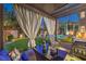Inviting covered patio with comfortable seating, lush landscaping, and a view of the pool at 7908 Horse Bridle St, Las Vegas, NV 89131