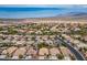 Expansive aerial view of a desert community featuring homes with tile roofs, solar panels, and mountain views at 8340 Jeremiahs Lodge Ave, Las Vegas, NV 89131