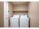 Bright laundry room with a white washer, dryer, and convenient overhead shelving at 8340 Jeremiahs Lodge Ave, Las Vegas, NV 89131