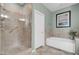 Tiled bathroom with glass enclosed shower, separate tub, and stone tile accents throughout at 9900 Summer Ash Ct # 101, Las Vegas, NV 89134