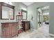 Dual sink bathroom with stone floors, wood cabinets, neutral walls and a separate water closet at 9900 Summer Ash Ct # 101, Las Vegas, NV 89134