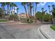 Inviting gated entrance of a residential community lined with palm trees under a sunny sky at 9900 Summer Ash Ct # 101, Las Vegas, NV 89134