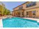 Backyard with swimming pool has waterfall, covered patio, and second-story architecture at 9992 Peak Lookout St, Las Vegas, NV 89178