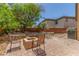 Inviting backyard patio features a stone fire pit with chairs and mature trees at 9992 Peak Lookout St, Las Vegas, NV 89178