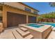 An exterior view of the home showcasing the covered patio, pool, and spa at 9992 Peak Lookout St, Las Vegas, NV 89178