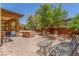 This cozy backyard boasts a stone fire pit, built-in grill, and covered patio at 9992 Peak Lookout St, Las Vegas, NV 89178
