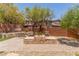 Backyard has a stone firepit, lush landscaping and a tiered stone walkway at 9992 Peak Lookout St, Las Vegas, NV 89178