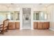 A luxurious bathroom with dual sinks, tiled flooring, and hallway access to the bedroom and shower at 9992 Peak Lookout St, Las Vegas, NV 89178