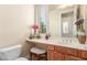 Well-lit powder room with vanity, white countertop, and decorative flowers, offering a fresh ambiance at 9992 Peak Lookout St, Las Vegas, NV 89178