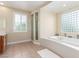 An opulent bathroom with a soaking tub, walk-in shower, and vanity with a chair for relaxation at 9992 Peak Lookout St, Las Vegas, NV 89178