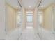 An elegant bathroom featuring dual mirrored closets with a view of a soaking tub with a textured glass window at 9992 Peak Lookout St, Las Vegas, NV 89178