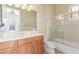 Well-lit bathroom featuring a dual sink vanity and a shower-tub combination with glass doors at 9992 Peak Lookout St, Las Vegas, NV 89178