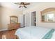 Spacious bedroom featuring hardwood floors, ceiling fan, and a classic wood dresser at 9992 Peak Lookout St, Las Vegas, NV 89178