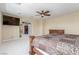 A spacious bedroom featuring a ceiling fan, TV, and an adjoining room with plush seating at 9992 Peak Lookout St, Las Vegas, NV 89178