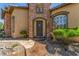 Stunning front entrance with stone accents, mature landscaping, and a decorative water feature at 9992 Peak Lookout St, Las Vegas, NV 89178