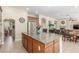 Open kitchen showcases wood cabinets, granite countertops, stainless steel appliances, and a center island flowing into the living area at 9992 Peak Lookout St, Las Vegas, NV 89178