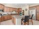 Updated kitchen features wood cabinets, granite countertops, stainless steel appliances, and a convenient center island with seating at 9992 Peak Lookout St, Las Vegas, NV 89178