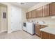 Functional laundry room with washer, dryer, sink, and ample cabinet space at 9992 Peak Lookout St, Las Vegas, NV 89178