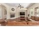 Inviting living room features a cozy fireplace, ceiling fan and a comfortable brown leather sofa at 9992 Peak Lookout St, Las Vegas, NV 89178