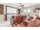 A media room showcasing a projector screen, comfortable recliners, and stylish ceiling fan at 9992 Peak Lookout St, Las Vegas, NV 89178