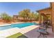 This backyard features a large in-ground pool and covered patio seating area at 9992 Peak Lookout St, Las Vegas, NV 89178