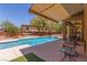The sprawling backyard features a large in-ground pool and covered patio at 9992 Peak Lookout St, Las Vegas, NV 89178