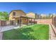 Private backyard featuring a covered patio, artificial grass, and secured by brick fencing at 10072 Pelham Park Ave, Las Vegas, NV 89148