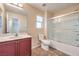 Well-lit bathroom features vanity, large mirror and a shower-tub combination with sliding glass doors at 10072 Pelham Park Ave, Las Vegas, NV 89148
