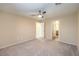 Neutral bedroom featuring plush carpet, ceiling fan, and bright natural light at 10072 Pelham Park Ave, Las Vegas, NV 89148
