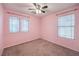 Bright bedroom with two windows and neutral carpet, painted with a pink interior at 10072 Pelham Park Ave, Las Vegas, NV 89148