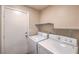 Functional laundry area featuring a side-by-side washer and dryer and overhead shelving at 10072 Pelham Park Ave, Las Vegas, NV 89148