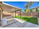 Covered patio with artificial grass backyard offers a perfect outdoor living space at 10072 Pelham Park Ave, Las Vegas, NV 89148