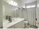 Bright bathroom featuring a large mirror, single vanity, and shower-tub combo at 10605 Moon Flower Arbor Pl, Las Vegas, NV 89144