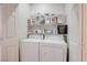 Laundry room with washer, dryer, storage shelves, and a white door at 10605 Moon Flower Arbor Pl, Las Vegas, NV 89144