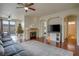 Spacious living room with a stone fireplace, dark wood floors, and an adjacent dining area at 10605 Moon Flower Arbor Pl, Las Vegas, NV 89144