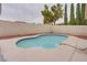 Inviting kidney-shaped pool with blue tile trim in a private backyard with perimeter wall and desert landscaping at 10605 Moon Flower Arbor Pl, Las Vegas, NV 89144