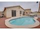 Backyard featuring a kidney-shaped pool, patio area, and sliding glass doors providing direct access to the home at 10605 Moon Flower Arbor Pl, Las Vegas, NV 89144