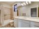 Bathroom featuring white cabinets, a tub and shower combination, and a large mirror at 10671 Capesthorne Way, Las Vegas, NV 89135