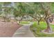 A scenic path winds through lush greenery and trees, within the community at 10671 Capesthorne Way, Las Vegas, NV 89135
