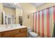 Cozy bathroom featuring a wood vanity, toilet and striped shower curtain at 1187 Mohave Dr, Mesquite, NV 89027