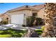 Close up of the home's exterior showing two car garage, desert landscaping and well-manicured lawn at 1187 Mohave Dr, Mesquite, NV 89027