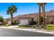 Charming home featuring a two-car garage, landscaped front yard with desert landscaping and vibrant palm trees at 1187 Mohave Dr, Mesquite, NV 89027
