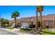 Charming home featuring a two-car garage, landscaped front yard with desert landscaping and vibrant palm trees at 1187 Mohave Dr, Mesquite, NV 89027