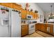 Well-lit kitchen featuring wooden cabinets, white appliances, and tile flooring at 1187 Mohave Dr, Mesquite, NV 89027