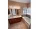 Bathroom featuring a double vanity with a bathtub and a large window at 1318 Pine Terrace Ct, North Las Vegas, NV 89031