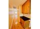 Bright hallway with wooden floors and wooden cabinets with dark countertops at 1318 Pine Terrace Ct, North Las Vegas, NV 89031