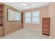 Bright bedroom with built-in storage, two windows, ceiling fan, and tile floor at 1735 Black Fox Canyon Rd, Henderson, NV 89052