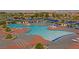 Aerial view of a spacious community pool with lounge chairs and umbrellas at 1735 Black Fox Canyon Rd, Henderson, NV 89052